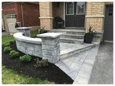 a stone wall and steps in front of a house