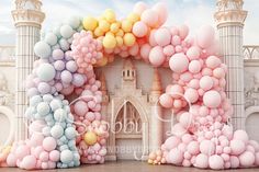 an arch made out of balloons in front of a castle