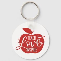 an apple shaped keychain with the words teach love inspire written in red on it