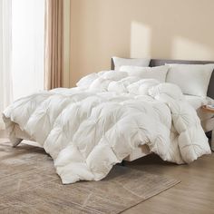 a large white comforter on a bed in a room