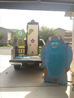 two cardboard monsters sitting in the back of a truck