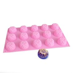 a pink cake pan filled with chocolates next to a blue ball