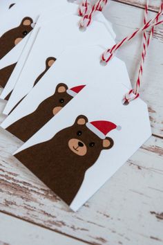 four brown bear gift tags with red and white striped twine hanging from the top