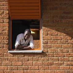 a man is looking out the window of his house