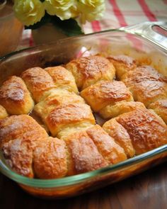 a casserole dish filled with pastries sitting on top of a wooden table