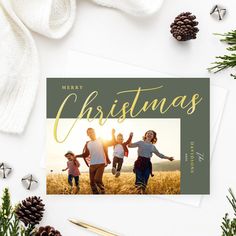 a christmas card with the words merry christmas on it and two children running in an open field