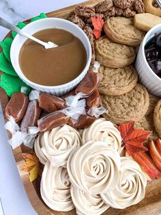 a wooden platter filled with cookies and desserts