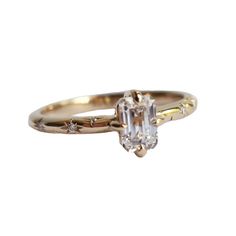 an engagement ring with a baguette cut diamond in the center and three diamonds on each side