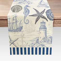 a table runner with blue and white sea life on it, along with a lighthouse