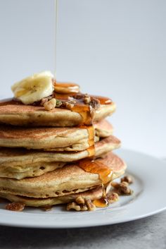 a stack of pancakes with syrup and bananas on top