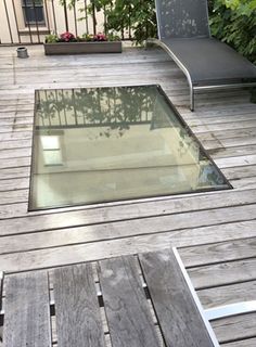 an empty swimming pool in the middle of a wooden deck