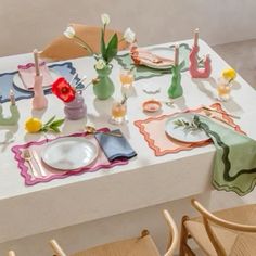 a table set with plates, napkins and flowers