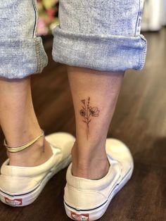 a woman's foot with a small flower tattoo on her left side calfocks