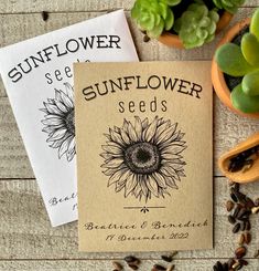 two seed packets sitting on top of a wooden table next to succulents