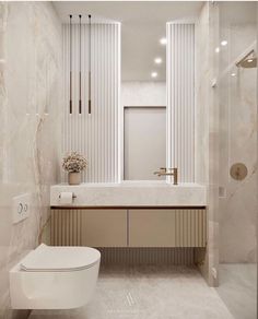 a white toilet sitting next to a walk in shower under a bathroom mirror above a sink