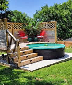 an above ground pool with steps leading up to it and two red chairs in the background