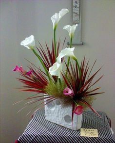 a vase filled with white flowers on top of a table