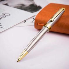 a pen sitting on top of a table next to an orange case