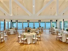 a large room with tables and chairs set up for a formal function at the beach