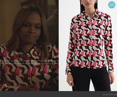 the young woman is wearing a red and black shirt with geometric print on it, while she