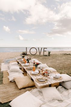 a picnic table set up on the beach with love sign