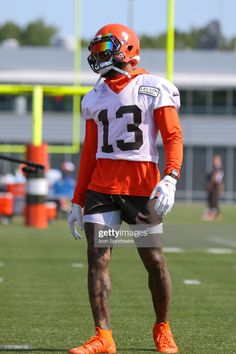 a football player wearing an orange and white uniform on the field