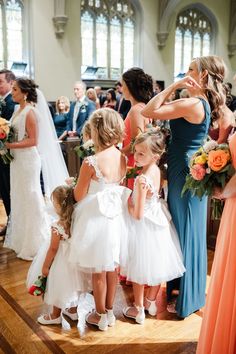 the bride and her flower girls are getting ready to walk down the aisle