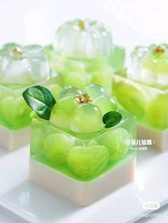 four small square dishes filled with green and white candies on top of a plate