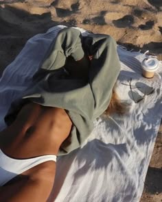 a woman laying on top of a white towel