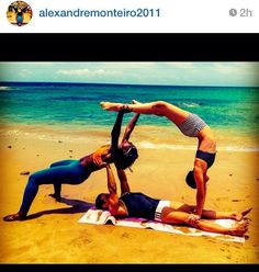 two people are doing yoga on the beach