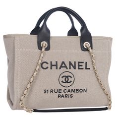 Authentic Chanel tannish brown and black Deauville shoulder bag tote. Features large canvas and leather exterior, fabric interior with zipper pocket and 2 slip pockets, and silver hardware. Authenticity hologram stamp reads G6TLU5AJ Made in Italy Strap drop: 13" Handle drop: 5" Large Canvas, Zipper Pocket, Chanel, In Italy, Italy, Shoulder Bag, Tote Bag, Zipper, Canvas