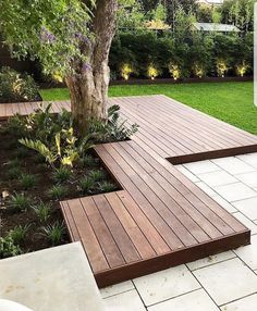 a wooden bench sitting next to a tree on top of a white tile flooring