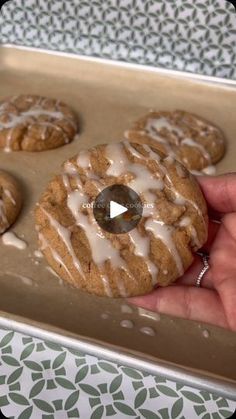 a hand holding a cookie with icing on it