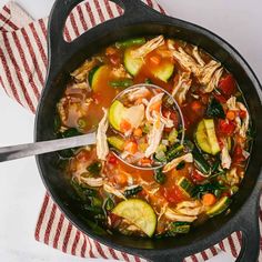 a pot filled with soup and vegetables on top of a table