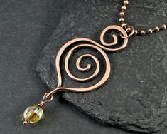 This pendant was made with copper wire and a Czech glass bead, and comes on a copper ball chain. Measurements Pendant width: 25 Millimetres; Pendant height: 62 Millimetres ✩ The item comes in a branded gift box- perfect for gifting.  ✩ All items are handcrafted by myself and every effort is taken to produce a high quality product.  ✩ Copper and sterling silver jewellery care: copper and sterling silver pieces will tarnish over time. To restore the shine simply polish the piece using a jewellery Copper Wire Art Short, Wire Pendant Tutorial Simple, Handmade Copper Jewelry, Wire Wrapped Stone Jewelry, Wire Wrap Jewelry Designs, Copper Jewellery, Spiral Necklace, Wire Jewellery, Wire Wrap Pendant