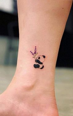 a small tattoo on the ankle of a girl with a panda bear and lavender flowers