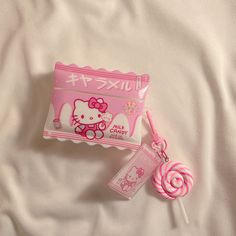 a hello kitty candy bar and lollipop on a bed