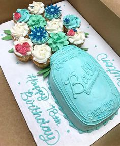 cupcakes in a box with blue frosting and flowers