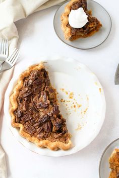 a slice of pecan pie on a plate with a fork and napkin next to it