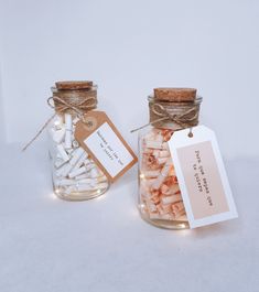 two glass jars filled with marshmallows and tags