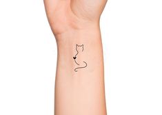 a person's arm with a cat tattoo on the left side of their wrist