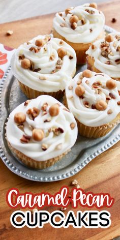 several cupcakes with white frosting and nuts on top sitting on a plate