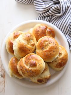 small rolls with poppy seed sprinkles in a white bowl on a table