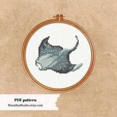 a cross stitch pattern of a stingfish in grey and white on a beige background