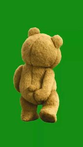 a brown teddy bear sitting on top of a green screen with its arms folded up