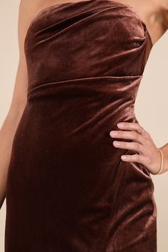 a woman in a brown dress with her hands on her hips