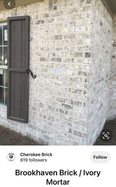 a brick house with an open window and shutters