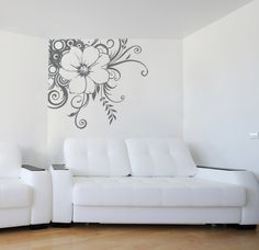 a white couch sitting next to a white chair in a living room on top of a hard wood floor