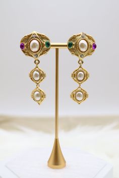 These matte gold tiered drop clip-on earrings feature an array of multi-colored stones arranged in a graceful cascading design. The vibrant stones set against the subtle matte gold create a striking contrast, making these earrings a bold and fashionable choice for those without pierced ears. Length: 2.50” Width: 1.14” Closure: Clip-On Earrings Material: Brass with 18K Gold Plating with Rhodium Coating Lead Free and Hypoallergenic Elegant Multicolor Clip-on Earrings, Ariel Wedding, La Wedding, Colored Stones, Holiday Jewelry, Wedding Weekend, Dream Jewelry, Pierced Ears, Matte Gold