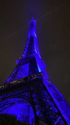 the eiffel tower lit up in blue at night